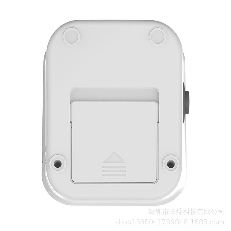 Bottom view of a white electronic blood pressure monitor showing battery compartment and screw holes